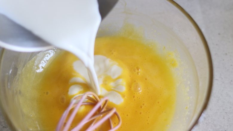 舒芙蕾芝士蛋糕,煮沸的牛奶，倒入蛋黄糊中，拌匀。