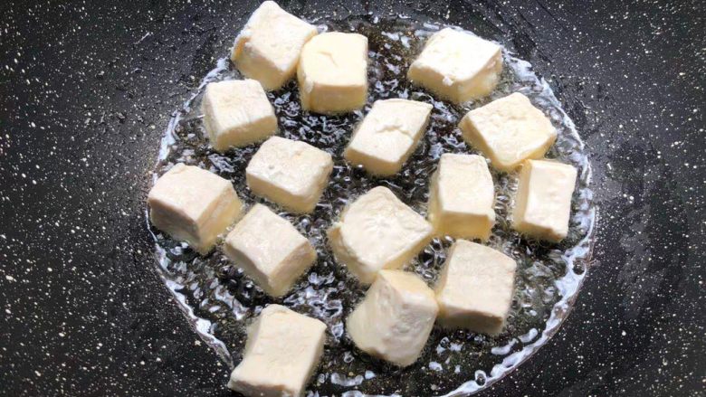 杂蔬豆腐,锅里放入适量油烧热，把裹好淀粉的豆腐放到锅里煎至六面金黄，煎好夹入盘里待用。