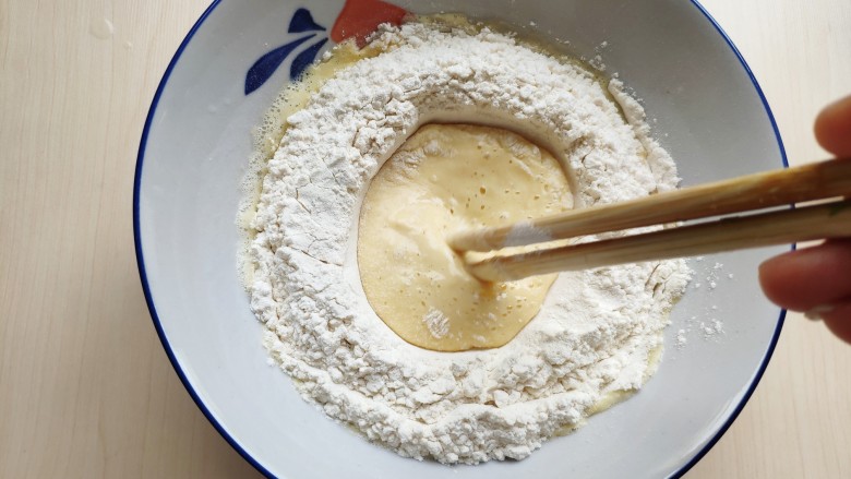 茴香小油条（不用手揉）,倒入面粉，用筷子从中间往外将蛋液和面粉混合成面糊。