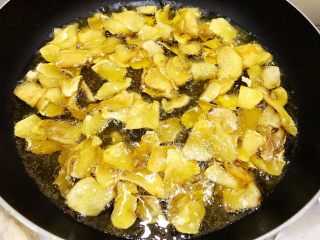红薯的终极吃法——芝麻苕酥糖,锅里倒入植物油，油温升高后转小火分次放入半干的红薯片慢慢炸至金黄