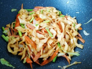 蔬菜火腿炒刀削面,加入酱油翻炒均匀。