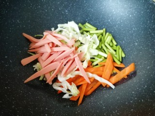 蔬菜火腿炒刀削面,炒锅内倒适量的食用油烧热，下入准备好的蔬菜火腿肠。