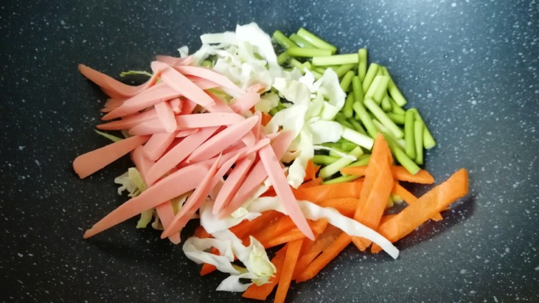 蔬菜火腿炒刀削面,炒锅内倒适量的食用油烧热，下入准备好的蔬菜火腿肠。