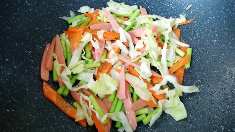 蔬菜火腿炒刀削面,翻炒至蔬菜变色。