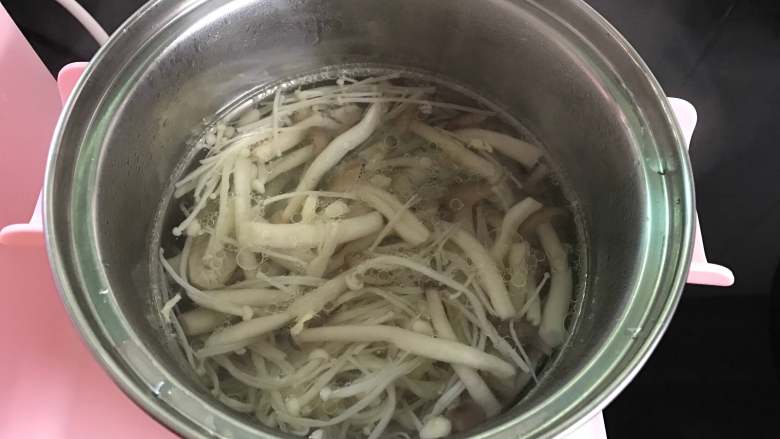 鸡蛋菌菇汤,煮锅中加入适量水，煮开后把焯过水的蟹味菇和金针放入锅中。