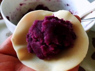 饺子皮紫薯饼,拿出一个饺子皮，将揉成团的紫薯放在上面。如果把控不好紫薯的量，可以先把紫薯捏成圆球。