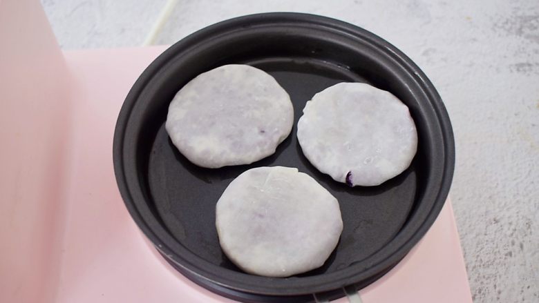 饺子皮紫薯饼,平底锅刷一层薄薄的食用油，再放入紫薯生胚，小火慢煎