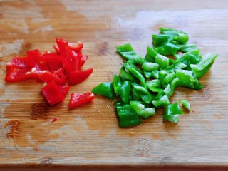 彩椒爆花蛤,首先将红绿椒洗干净，去根、去籽、切小块。