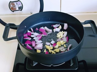 彩椒爆花蛤,油温7成时，加入切好的蒜姜，洋葱煸炒出香味。