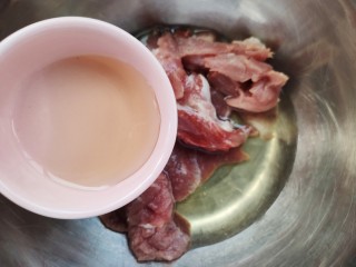 金牌福州荔枝肉,把切好的瘦肉块儿放进盆里，加入一个蛋清，加入一勺料酒