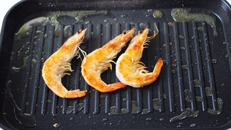 蒜香海虾炒芦笋,把海虾煎至两面金黄色，并且煎出虾油后，盛出备用。