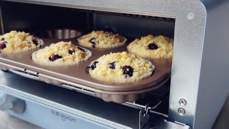 金酥粒蓝莓爆浆蛋糕,放入已经提前预热到185度的东菱3706日系小烤箱里，烘烤25分钟左右（实际烘烤温度要根据自家烤箱脾气而定）