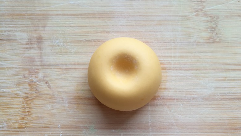 金苹果馒头（肉松包）,在馒头的顶部按下一个小坑。不用担心太深，醒发后就不这么明显了。