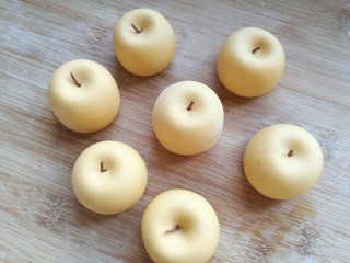 金苹果馒头（肉松包）,在凹下的中间挨个按上苹果把，金黄色的小苹果做好了。
山东有一种吃起来口感面面的，名字叫金帅苹果，就是这个样子。