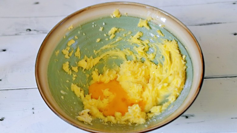 咖啡豆饼干,分两次加入全蛋液，继续启动电动打蛋器，打至蛋液与黄油完全融合。