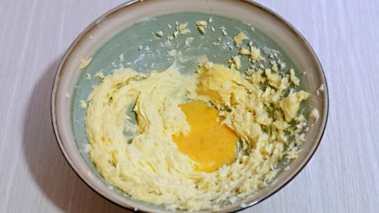 翡翠黄油饼干,分两次加入全蛋液，继续启动电动打蛋器，打至蛋液与黄油完全融合，再加入一半蛋液，同样打至完全融合即可。