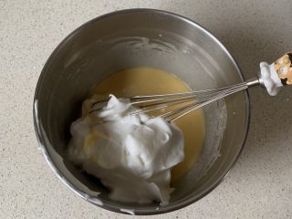 棉花蛋糕,取三分之一蛋白霜到蛋黄糊中翻拌均匀，然后倒入剩余的蛋白霜中，继续翻拌均匀
