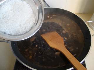 西班牙墨汁海鲜饭,倒入洗好的大米搅匀铺平，开锅后中火煮至半熟