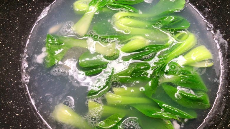 油泼面,锅里放入一勺盐，把小青菜放入烫熟。
