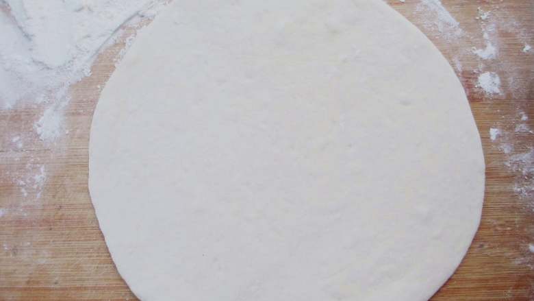 荷叶饼,取出面团按压排气，在面团上依然撒少许面粉，擀成1mm左右厚度的面片