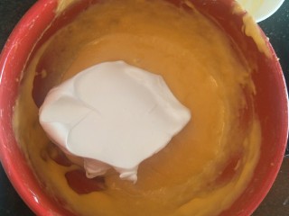 脆皮巧克力蛋糕卷,摇一勺蛋白放入蛋黄糊中搅拌。