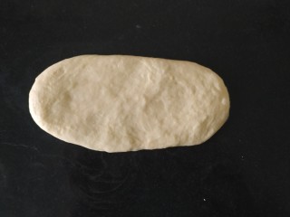 椰蓉心形面包,用手轻轻按压，再用擀面杖擀成牛舌形状的饼；