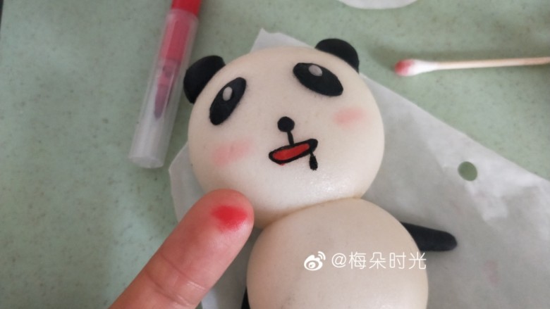 卡通馒头—小熊猫馒头,用红色烘培笔在手指上画几下，然后用棉棒蘸取颜色在熊猫的脸颊上轻轻涂几下，做腮红。不宜涂的太重。也可以用红曲粉溶于水代替。