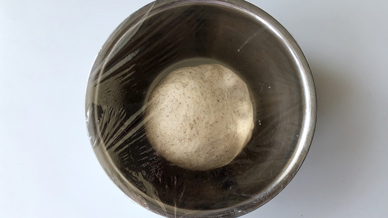 红糖黑麦养生面包,把面团放入干净的不锈钢盆里，盖好保鲜膜，放在温暖处发酵，建议温度28°，一个小时。