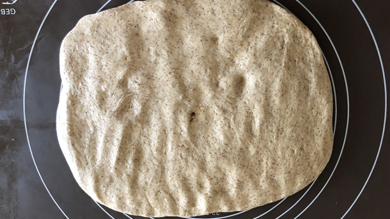 红糖黑麦养生面包,把面团放在揉面垫上按压排气。