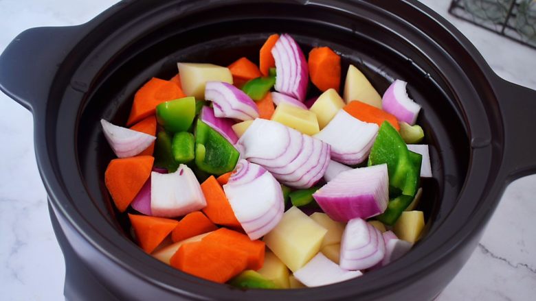 三汁焖锅,锅中倒入适量的食用油烧热，放入土豆、胡萝卜、洋葱、青椒