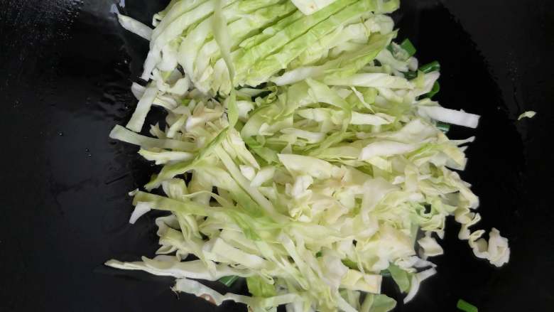 素炒粉丝卷心菜,加入卷心菜翻炒，这个时候最好用筷子来帮助翻炒，更容易使蔬菜同时成熟。

