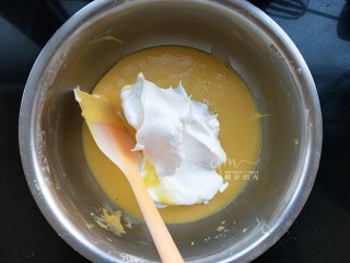 斑马纹戚风蛋糕,取三分一蛋清到蛋黄糊里翻拌均匀。记住不要画圈搅拌，以免消泡。