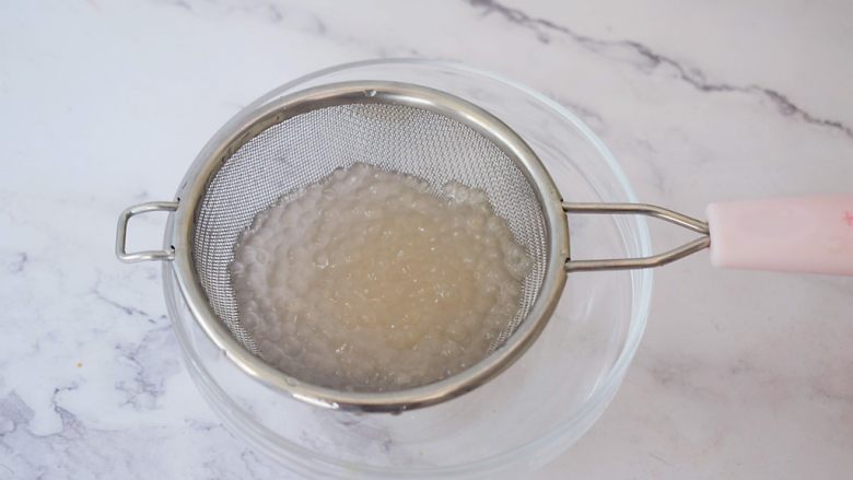 芒果西米露,捞出西米放在冷水中冲泡至粒粒分明不粘手，一定要冷水冲，不然最后会变成一团浆糊，然后沥干水分，放入碗中备用