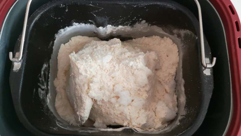 好吃又好看的椰蓉葡萄干吐司,将以上这些原料（黄油除外），按时先液体后粉类的顺序倒入面包桶中，用面包机将其和成面团。
