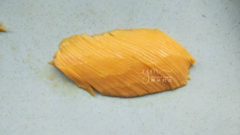 芒果思慕雪,剩下的一半芒果斜刀切成薄片，切厚了卷花容易断。