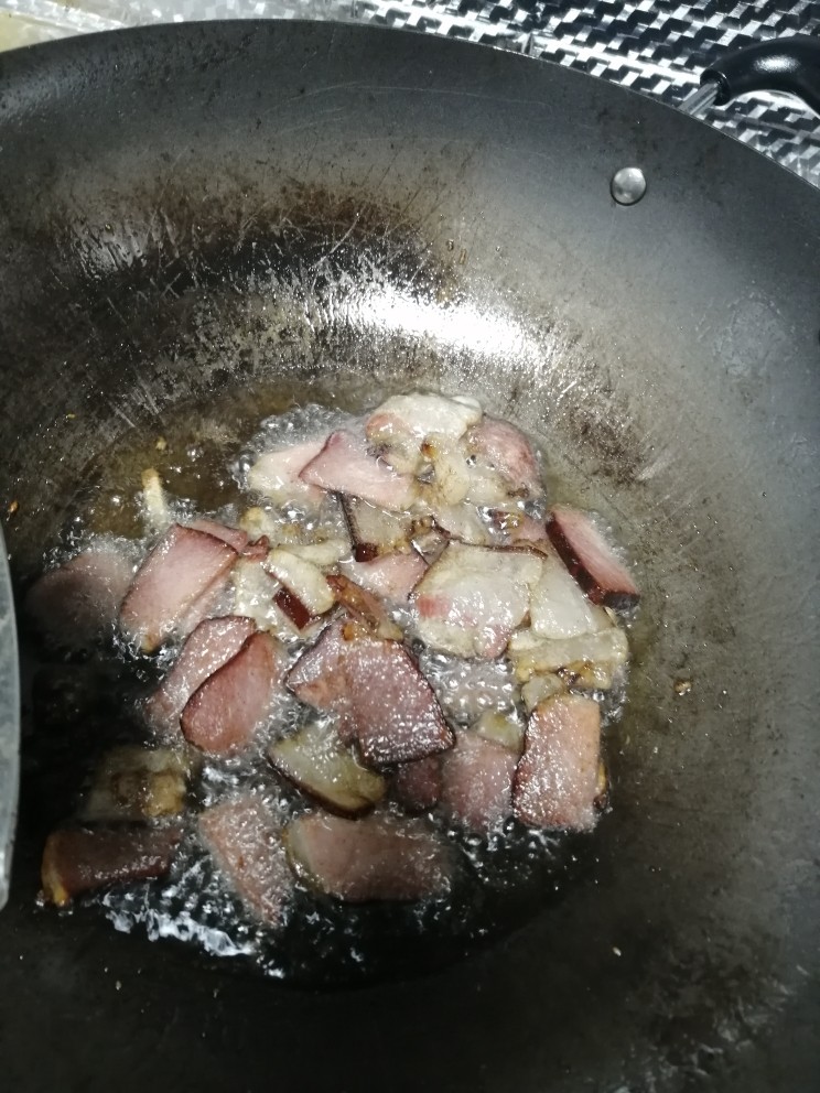 腊肉炒蒜苔,开火，放油，等油热了就把腊肉倒下去翻炒，翻炒至腊肉有点点焦。