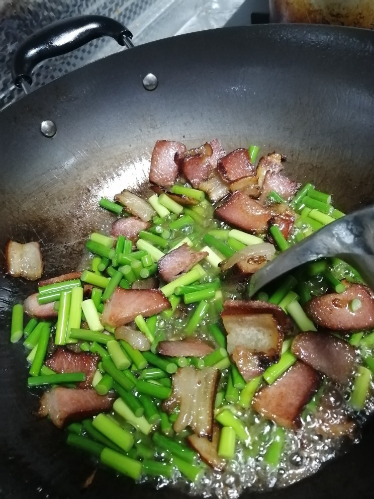 腊肉炒蒜苔,将蒜苔下锅一起翻炒。一起炒两分钟左右。