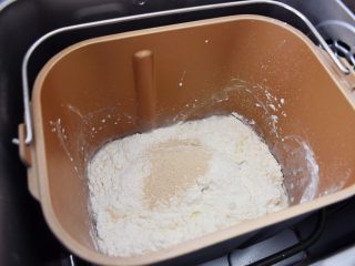 麻薯豆沙饼,把面团材料除了黄油，全部放入面包机桶中，先液体再固体顺序放入，启动揉面程序揉成团