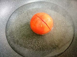 爆红网络的一个番茄饭,番茄顶部用刀划十字架。放入锅中煮两分钟待皮分离，取出撕掉皮。