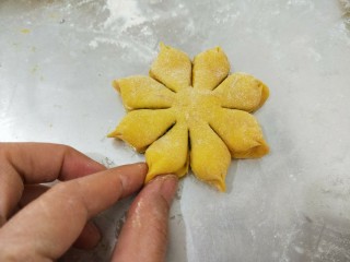 南瓜花样面包,最后用拇指和食指捏一下，捏出花瓣的样子；全部做好后放到烤箱，调到发酵功能，进行二发40分钟。

