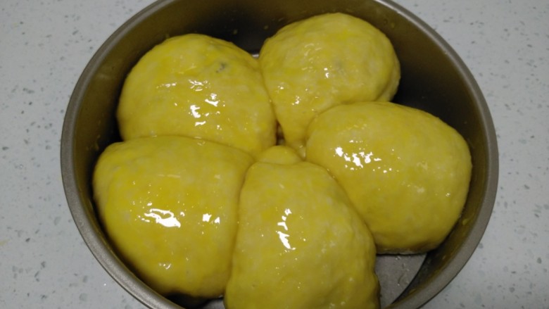 蒸葡萄干面包,待发酵至2倍大，均匀涂上蛋黄液。