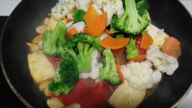 豆腐炒西红柿、西兰花、菜花,放入西兰花、菜花、胡萝卜 。