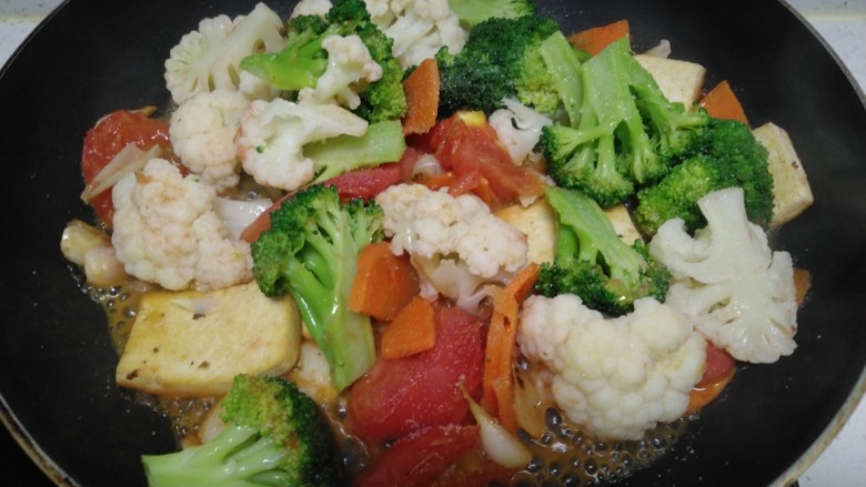 豆腐炒西红柿、西兰花、菜花,放入盐。