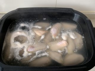 可乐鸡翅,鸡翅冷水下锅焯一下水、去浮沫。洗净后控干水份