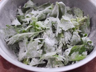 芹菜叶麦饭,把芹菜叶和面粉搅拌均匀，芹菜叶片片都沾满面粉就可以了。