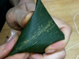 彩色三角粽,包的时候用拇指和食指压住两边，把上面的叶子往下压