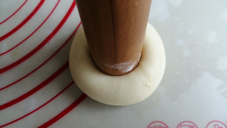 蓝莓酥粒面包,擀面棍的一头沾点面粉，在面团中间用力压一下