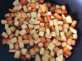 炒三丁,起鍋燒油，倒入土豆丁煎至兩面金黃，撈出備用。