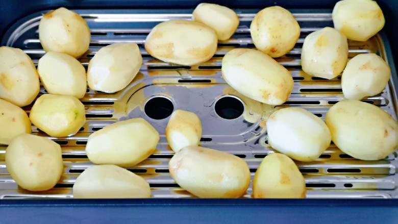 葱香椒盐小土豆,将去皮洗干净的小土豆放蒸屉上。