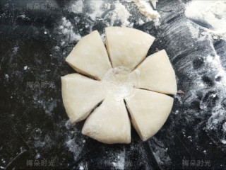 花朵豆沙面包,然后去取第一个做好的，按扁。用一个锋利的剪刀剪开边缘，剪成6份，中心留一个圆形不剪通。